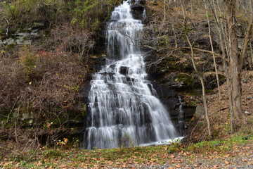 Fototapeta na wymiar A Small Waterfall Flowing Down a Steep Cliff