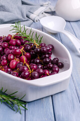 Baked bunches of dark grapes with rosemary