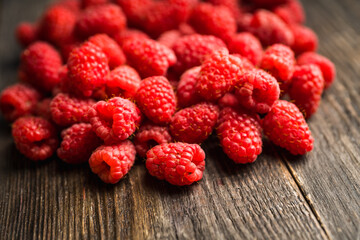 Freshly harvested raspberry on the rustic wooden background. Selective focus. Shallow depth of field.