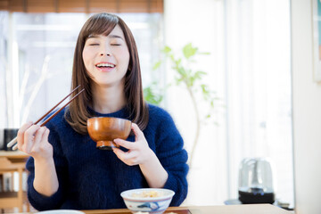 味噌汁を食べる女性