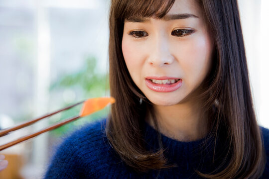 嫌いな食べ物を見つめる女性