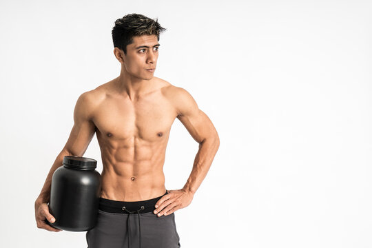 asian young man with muscular body carry a black bottle with one hand stand facing forward and look to side on isolated background