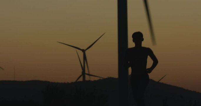The guy runs towards the camera at sunset. Silhouette shooting