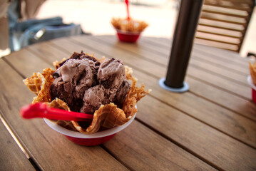 chocolate ice cream in a waffel bowl looks very delicious and creamy. you can get ice cream at the mall and it's a great way to have a fun time with friends and family. chocolate ice cream is yummy
