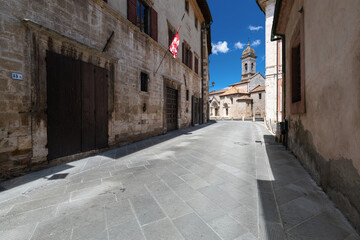 Wide angle view of the main street in a small italian medieval town, with the cathedral in the background