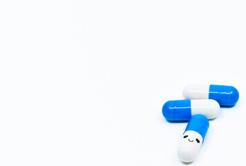 Smiling face blue capsules on the white background. The concept of effective drug against orphan diseases.