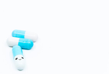 Smiling face mint capsules on the white background. The concept of effective drug against orphan...