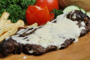 Grilled steak with mozzarella spills served on wooden tray