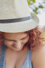 red-haired curly-haired girl in a summer braided headgear and jeans dress posing in the village ....