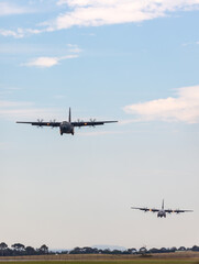 Fototapeta na wymiar Two large military cargo airplanes approaching to land.