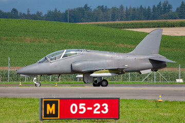 Air Force jet trainer aircraft taxiing down runway.