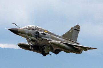 Camouflaged Air Force strike aircraft taking off.