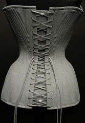 Closeup of vintage female corset on dark studio background	