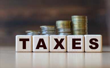 TAXES word on diced on a beautiful dark background with coins