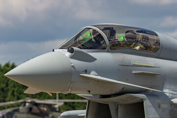 Two military pilots in the cockpit of a modern military fighter jet as it taxis for takeoff.