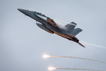 Fighter jet aircraft firing countermeasures flares to avoid missiles.