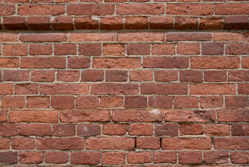 Naklejka premium A close-up of a fragment of an old historical brick wall. Horizontal orientation, selective focus.