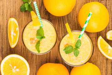 Fototapeta na wymiar glass of fresh orange juice with fresh fruits on wooden table