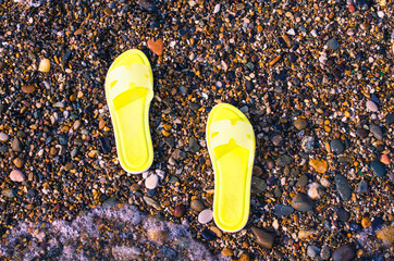 abandoned beach shoes on the sea beach, vacation on the coast, a person left their shoes on the...