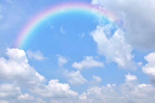 Abstract rainbow on beautiful blue sky and white clouds as background and wallpaper. 