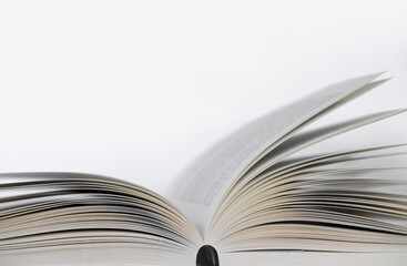 Opened book on the table with white background. Narrow depth of field