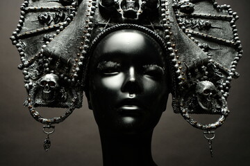 Head of mannequin in creative metal kokoshnick, dark studio background