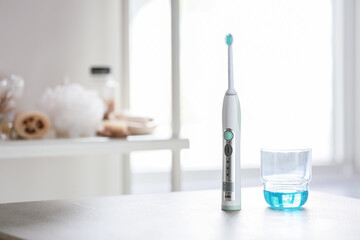 Electric tooth brush and mouth rinse on table in bathroom