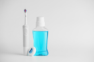 Tooth brush, mouth rinse and paste on light background