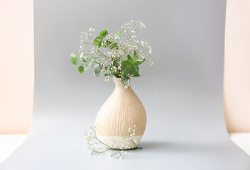 Beautiful vase with flowers on grey background