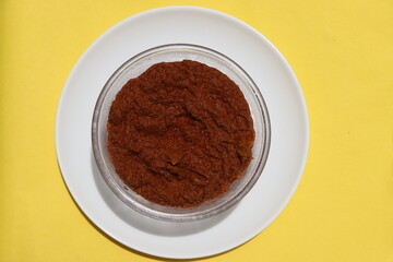 Red curry paste in glass bowl, basic ingredient for Indian curry or gravy made with various spices, tomatoes and onions.