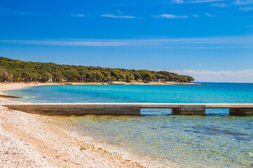 Adriatic sea shore in Croatia, Pag island, pine woods and long sand beach with pier, tourist destination