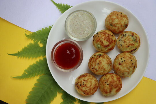 Appum or Appe, Appam or Mixed dal or Rava Appe served with green and red chutney. A Ball shape popular south Indian breakfast dish, Selective focus