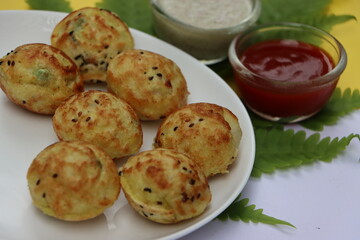 Appum or Appe, Appam or Mixed dal or Rava Appe served with green and red chutney. A Ball shape popular south Indian breakfast dish, Selective focus