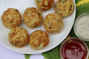 Appum or Appe, Appam or Mixed dal or Rava Appe served with green and red chutney. A Ball shape popular south Indian breakfast dish, Selective focus