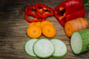 Carrots, red peppers and zucchini on a wooden table. Dietary food. Vegetables.