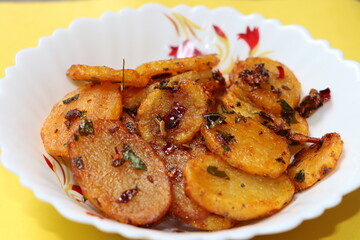 Aloo Katli or Potato Katli is an excellent and tasty asian dish, slices of fried potatoes, sauces and herbs, snack or starter 