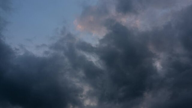 Disturbing gloomy sky and dark clouds movement. Gathering Storm Clouds With Sunset Light