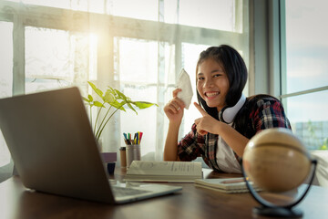 Asian female teenager smile and holding medical mask to show at home during covid19 pandemic. Basic equipment to help keep us safe new life.