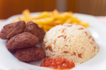 meatballs and rice with fried potatoes and tomato sauce