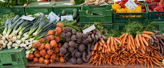 panorama view of a farmer market stall with many organic vegetables for sale