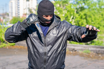 a bandit with a knife in his hand stands in a position ready to attack a person, a fight - obrazy, fototapety, plakaty