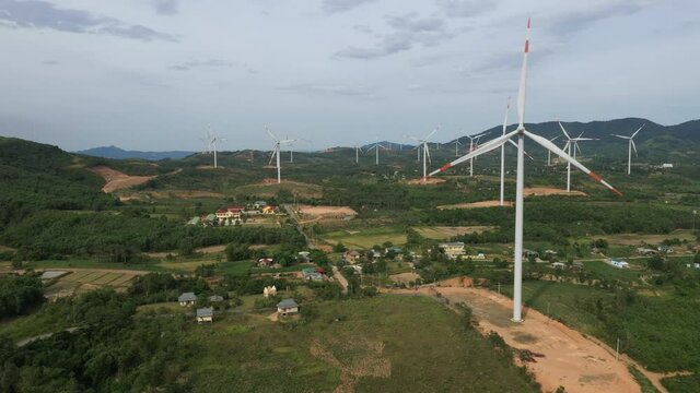 Aerial view of windmills farm for energy production on rice field, Huong Linh, Quang Tri, Vietnam. Wind power turbines generating clean renewable energy for sustainable development