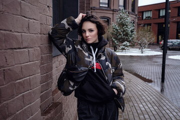 Stylish brunette woman in trendy apparel looking and enjoying winter in city.
