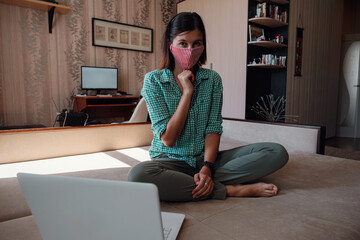 Business woman working from home wearing protective mask.