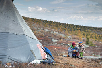 mongolian man with a tsaatan kid  in a landscape of Mongolia
