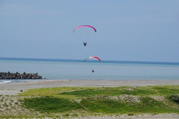 海岸沿いに飛ぶモーターパラグライダー
