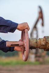 Oilman closes the valve on the pipe
