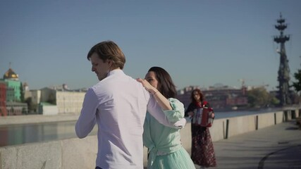 Dancers are dancing a Spanish dance on the river embankment. Street musicians and dancers.