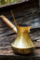 Vintage metal turk for making coffee on bark. Method for brewing coffee. Device for brewing natural coffee beans.