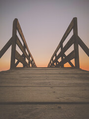 Wooden bridge to the beach at the Northern Litoral Natural Park in Esposende, Portugal. Scenic colorful sunset at the sea coast.